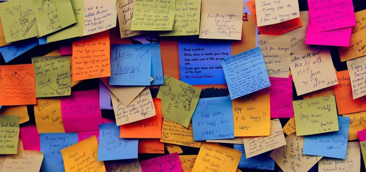 colourful post-it notes with scribbles on upon wall