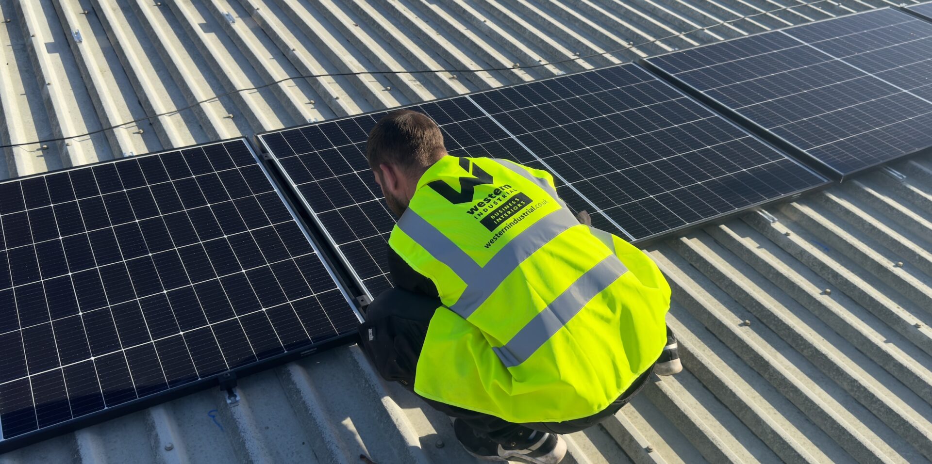 man installing solar panels at a roof top man installing solar panels at a roof top