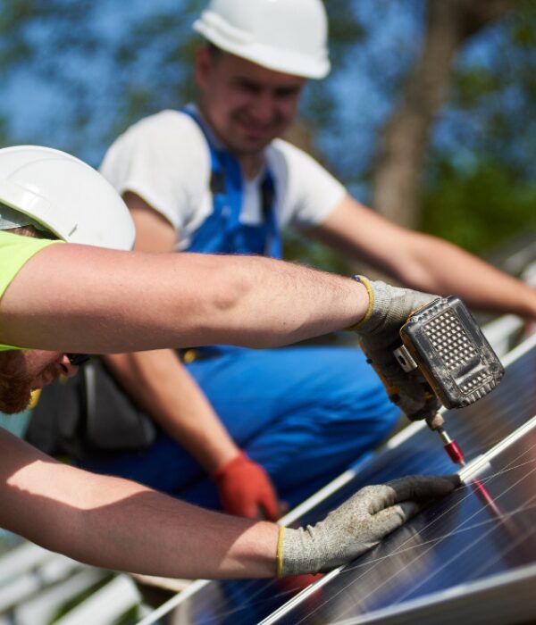 two men with hard hats on working upon solar panels two men with hard hats on working upon solar panels