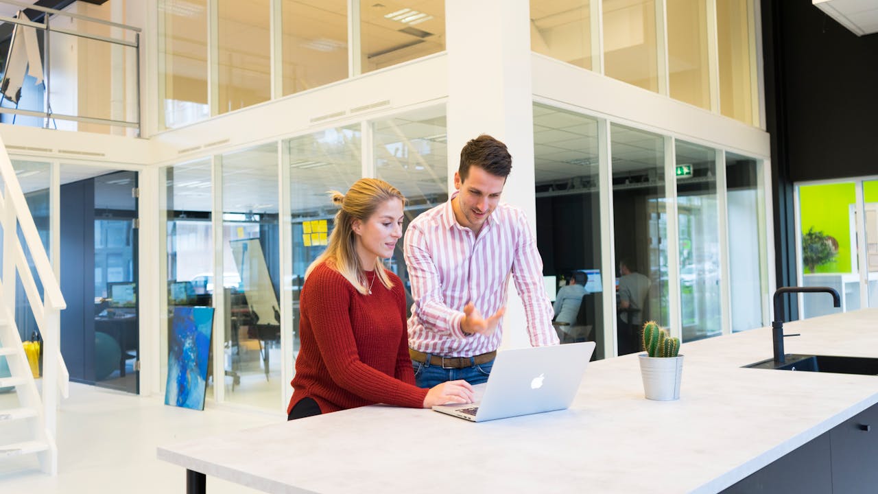 Man and woman stood around a laptop
